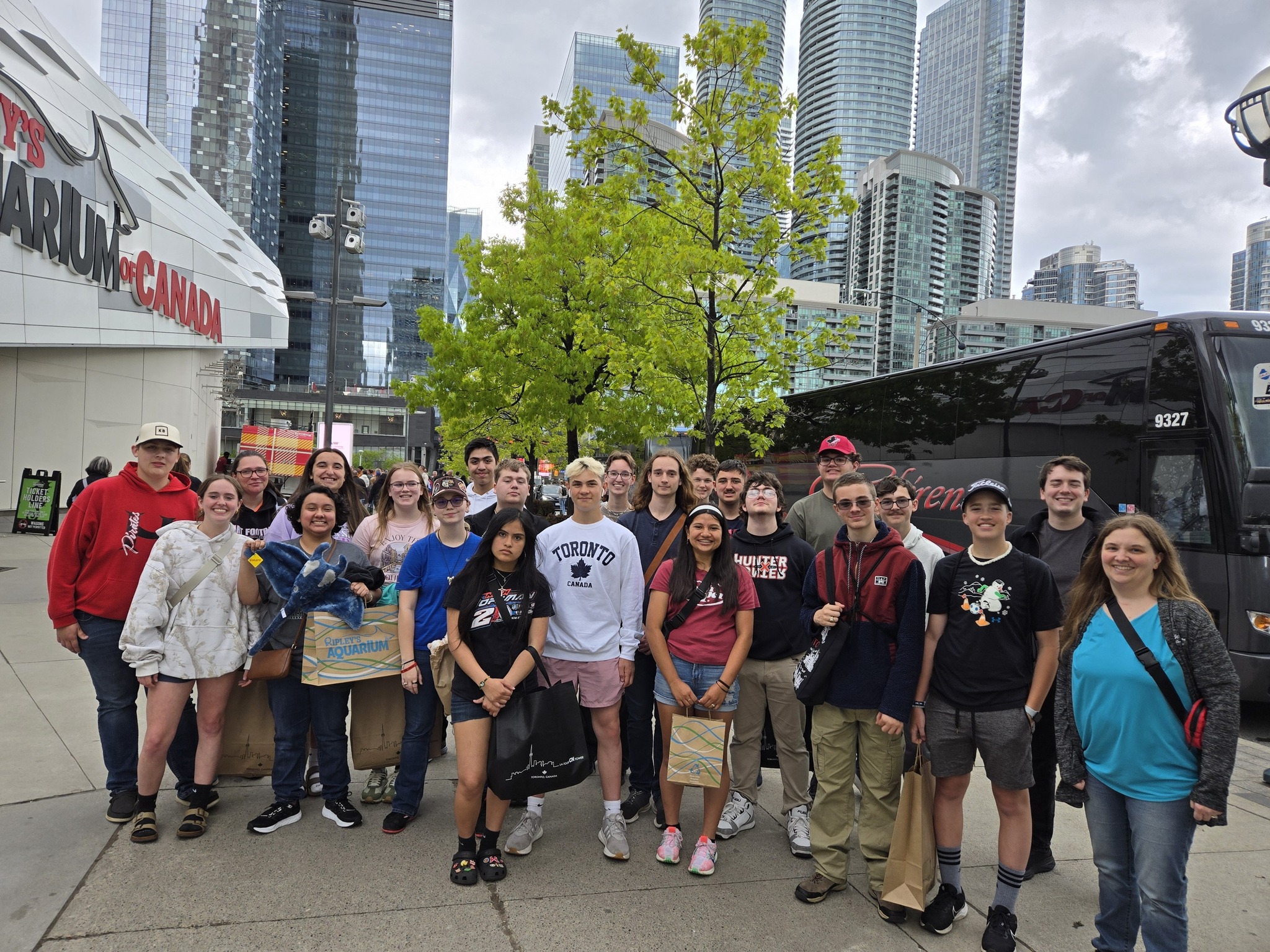 students posing for group photo in front of motorcoach