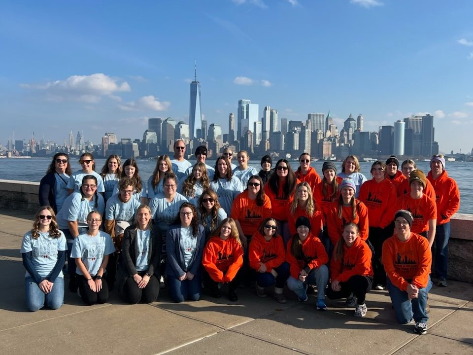 group posing in front of new york city skyline