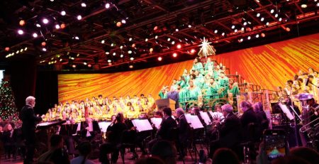 Wide shot image of entire stage performance of Disney's Candlelight processional featuring a mass choir and orchestra
