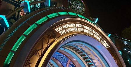 Epic Universe portal with sign saying "you wonder next what path to chart the answer lies within you heart"