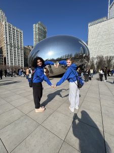 students posing with their arms bent to form a heart in front of Cloudgate/the bean