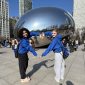students posing with their arms bent to form a heart in front of Cloudgate/the bean