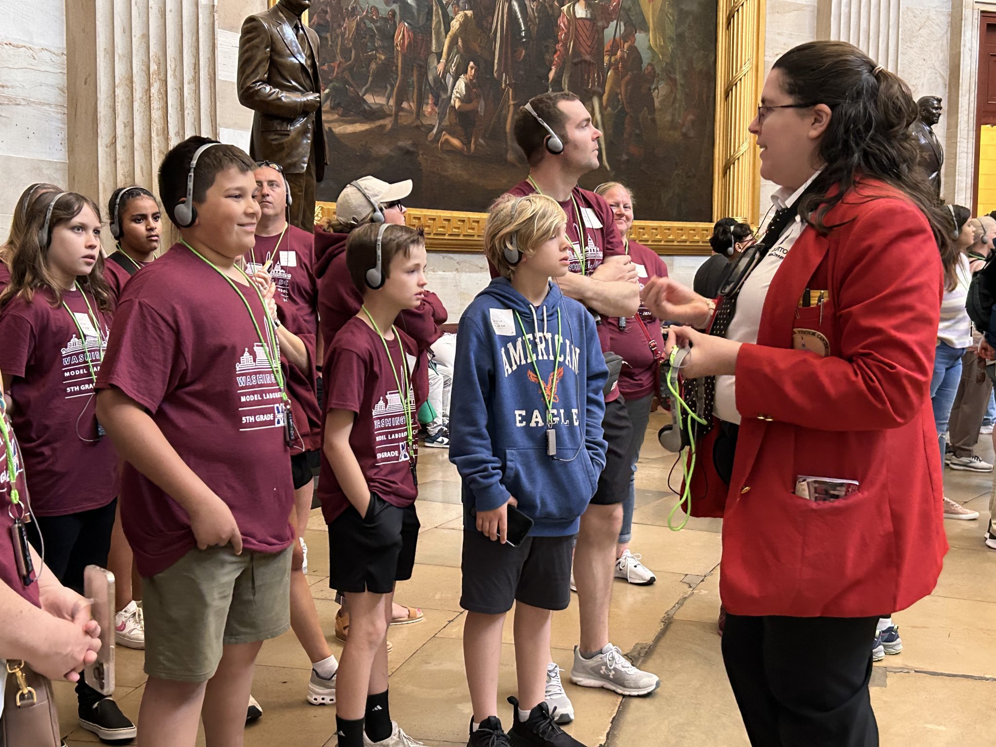 student standing in a museum listing to a tour guide