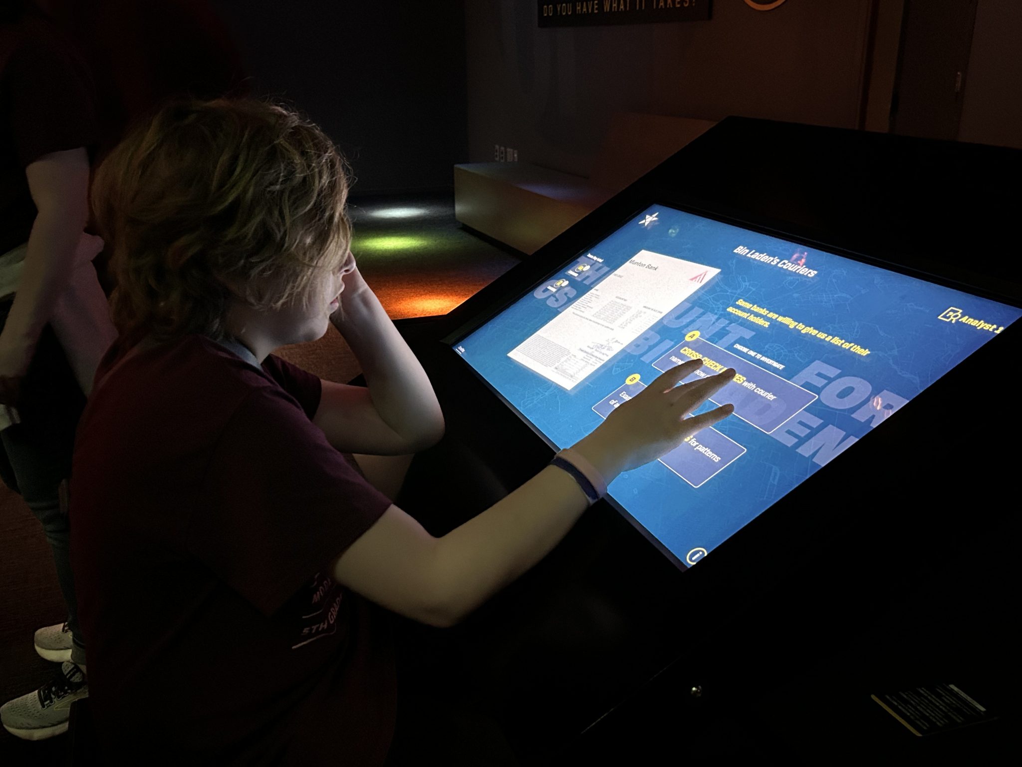 a student interacting with a screen exhibit