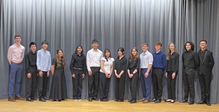 Students posing on stage smiling