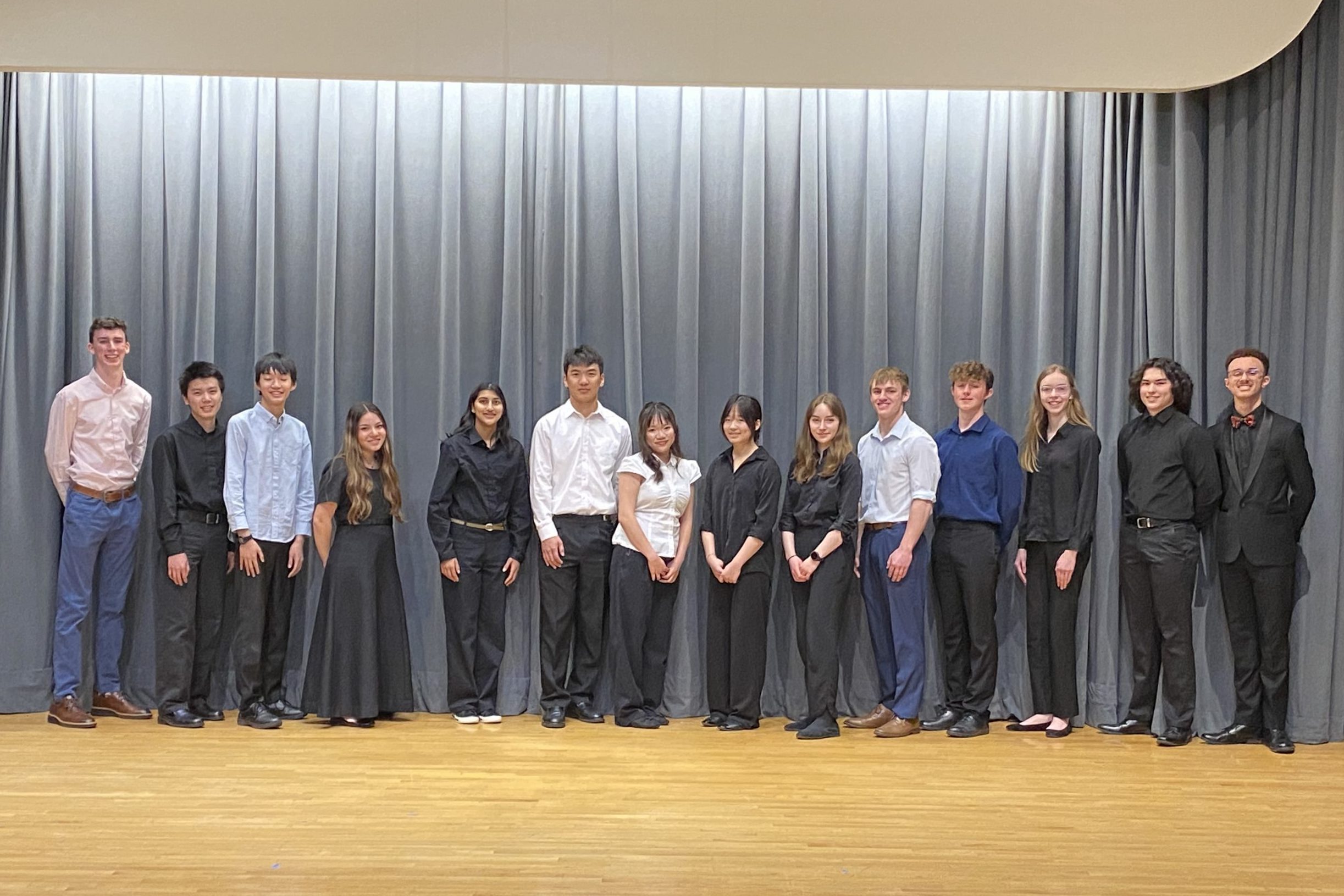Students posing on stage smiling